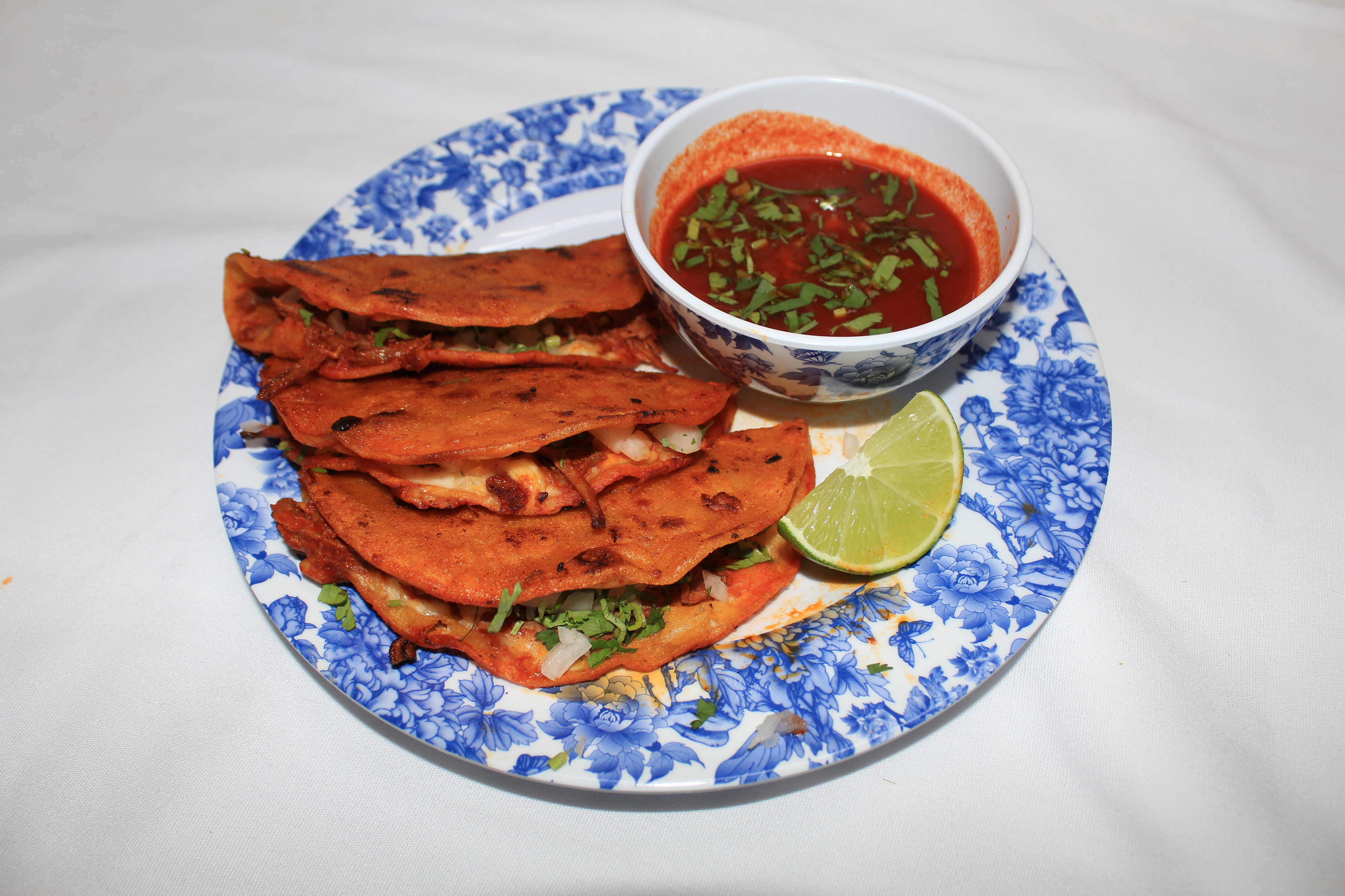 quesabirria on blue plate with consome