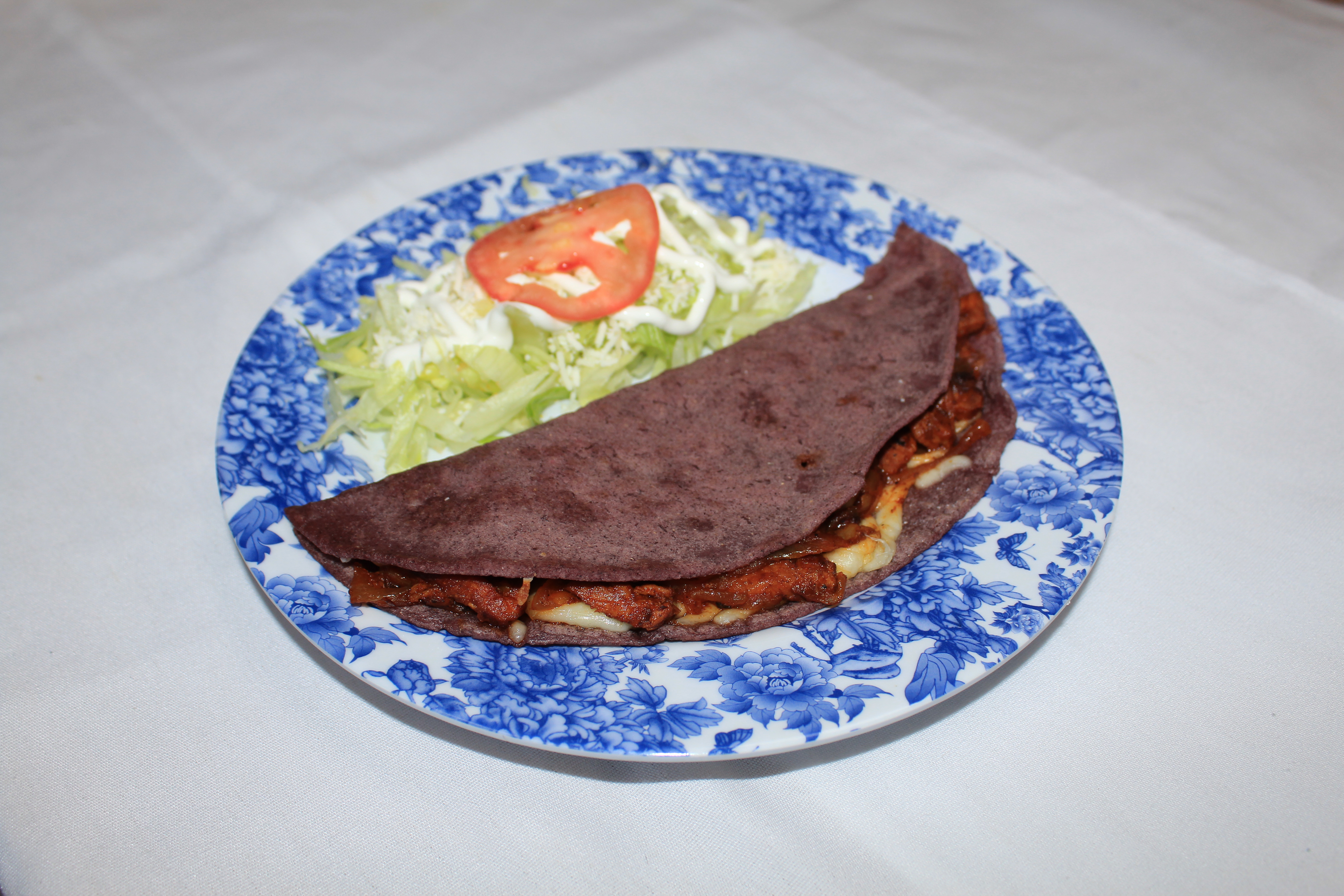 blue corn quesadilla on blue plate with side salad